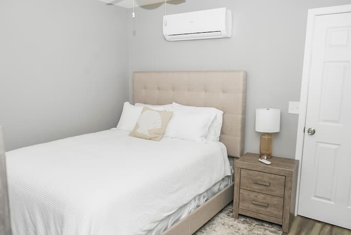 ห้องนอนที่เงียบสงบนี้มีจานสีเทาอ่อนนุ่มหัวเตียงหุ้มเบาะหนานุ่มและเครื่องนอนสีขาวคมชัดเพื่อความสะดวกสบายสูงสุด ห้องน้ำในตัวช่วยเพิ่มความสะดวกสบายในขณะที่การออกแบบที่สะอาดและเรียบง่ายสร้างสถานที่พักผ่อนที่เงียบสงบ