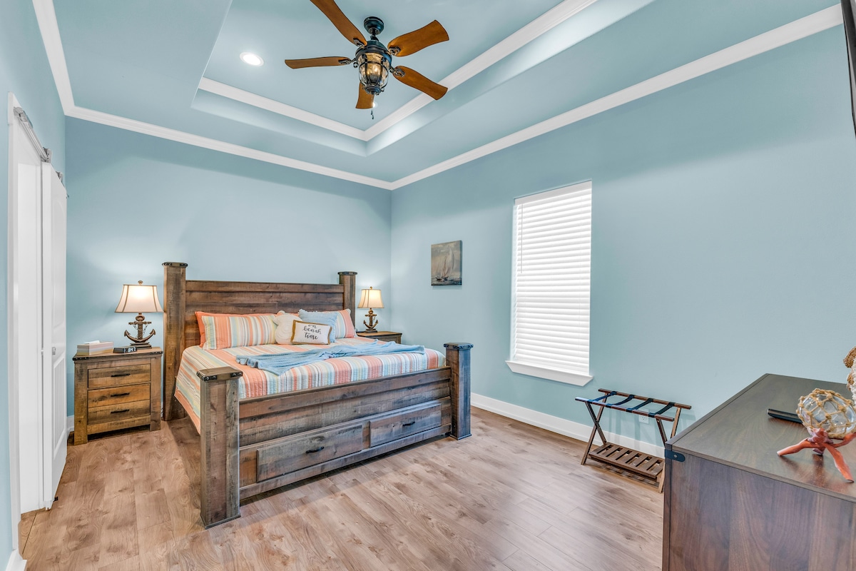 Amka katika paradiso chini ya upepo mzuri wa feni katika chumba cha mmiliki wa mfalme wako. Bafu la kina la bafu la chumba cha kulala na bafu la mvua linapiga kelele! Chomeka vifaa vyako muhimu zaidi vya kielektroniki kwenye kituo cha kuchaji cha meza. 