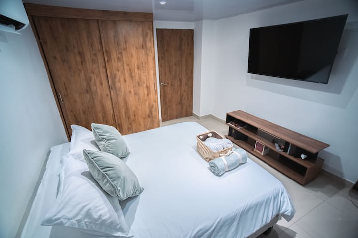 テレビ、さまざまな枕やリネン類をお楽しみください。 さらに、屋外の自然光がお部屋を照らし、居心地の良い雰囲気を作り出しています。