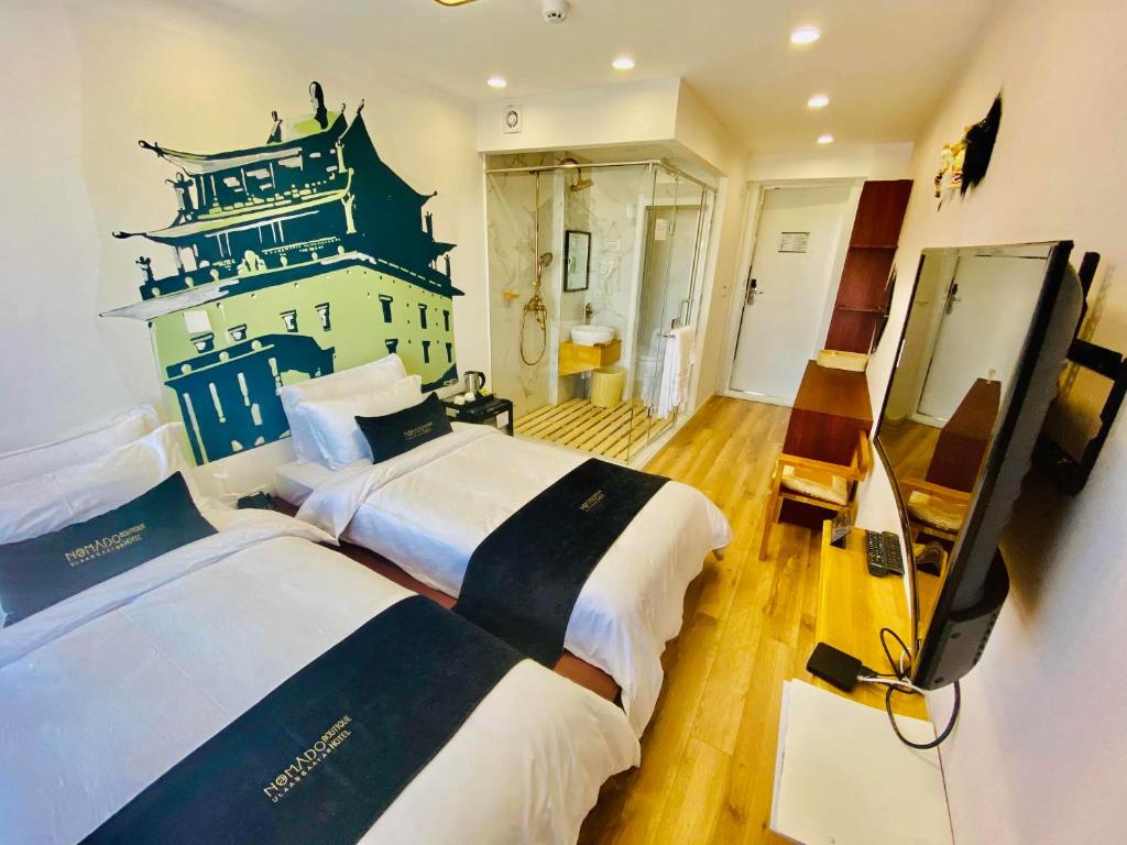 A modern hotel room features two spacious beds with crisp white linens, complemented by dark blue accents. A large wall mural depicting a traditional Mongolian structure adds character. A flat-screen TV is mounted on the wall, and a glass-enclosed shower area is visible in the background.