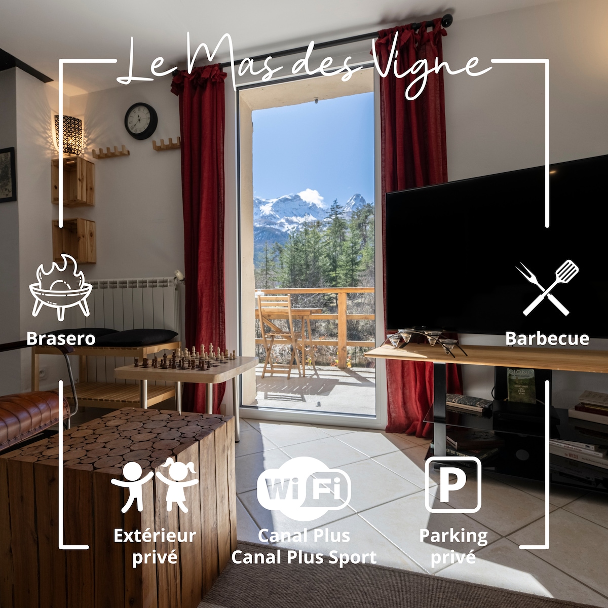 A cozy living area is showcased with a private balcony that offers views of the surrounding mountains. A flat-screen TV is set against a wood-accented wall, while large windows invite natural light and provide access to outdoor seating.