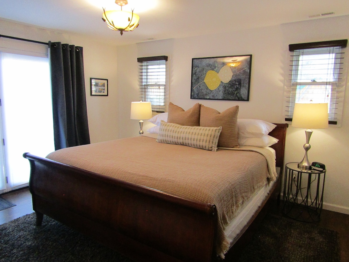 غرفة نوم رئيسية مع سرير بمقاس كينج وبياضات مريحة. 