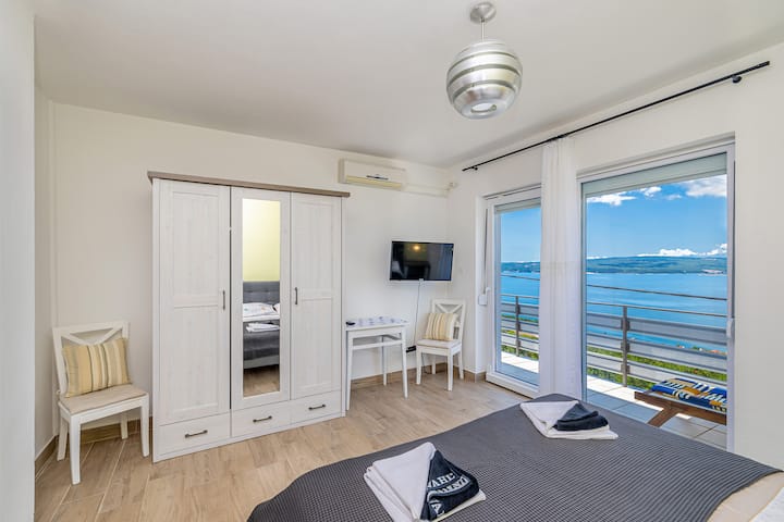 4. spavaća soba - stan na drugom katu
Pogled s bračnim krevetom, ormarom, TV-om i ulazom na balkon na drugom katu.
