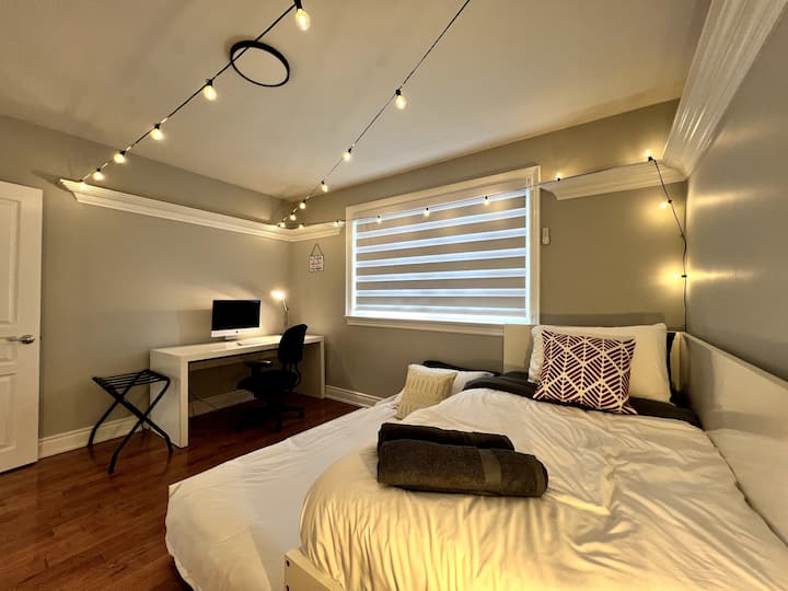 This inviting bedroom features a comfortable workspace, perfect for catching up on emails or indulging in a good book. The cozy atmosphere is complemented by a plush bed and stylish decor, a serene environment for relaxation and productivity.