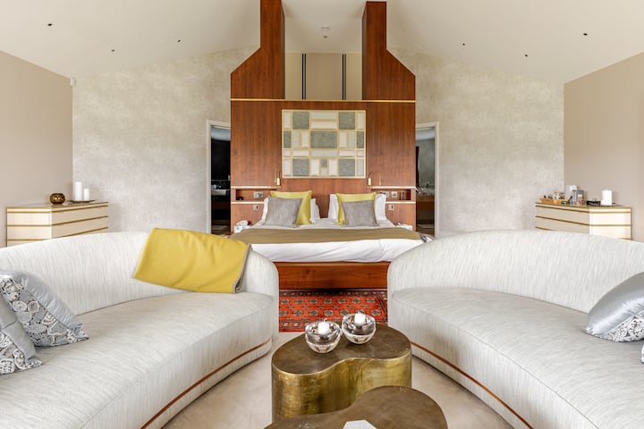 Une chambre avec salle de bains privative super-king avec des dressings, des lavabos, un sauna privé et un balcon, ainsi qu'une baignoire jacuzzi. 
