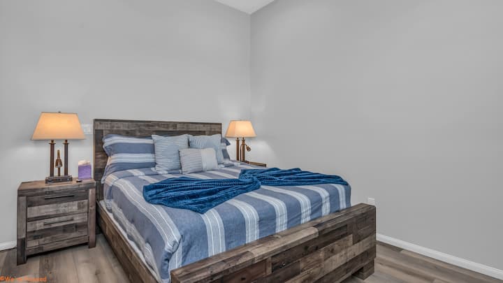Relájate en este dormitorio de estilo precioso con un diseño rústico y moderno, con una acogedora cama tamaño queen, puerta corrediza estilo granero, iluminación ambiental y sábanas de primera calidad. Un refugio tranquilo perfecto para noches de descanso y mañanas relajadas.