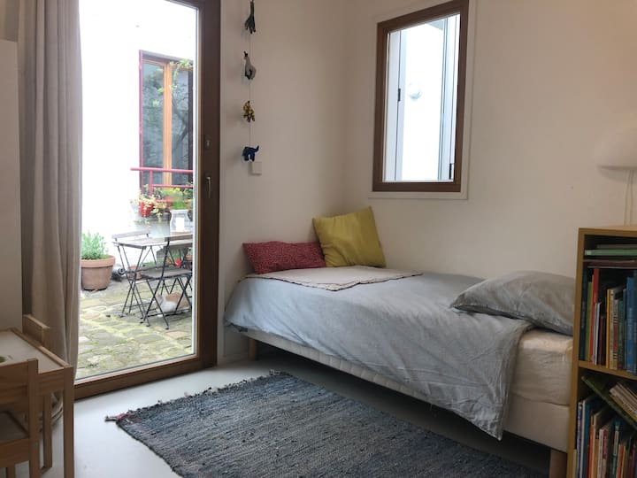 Në katin përdhes në vazhdimësinë e seminarit, një dhomë gjumi me një krevat tek (90x200), në një kat në oborrin e pyllëzuar. E përkryer për një fëmijë, por edhe e përshtatshme për një të rritur! 
Dhoma ka pamje nga tavolina e punës dhe banja me tualet