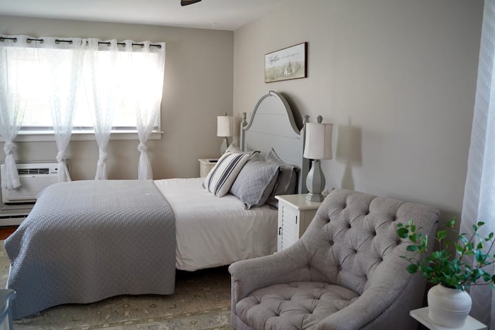 De hoofdslaapkamer op de begane grond is groot en heeft drie ramen om de zon binnen te laten.  Deze slaapkamer is voorzien van een tv en een groot bureau met comfortabele stoel en 2 extra stoelen om koffie te drinken terwijl je naar het ochtendnieuws kijkt. En suite badkamer ook!