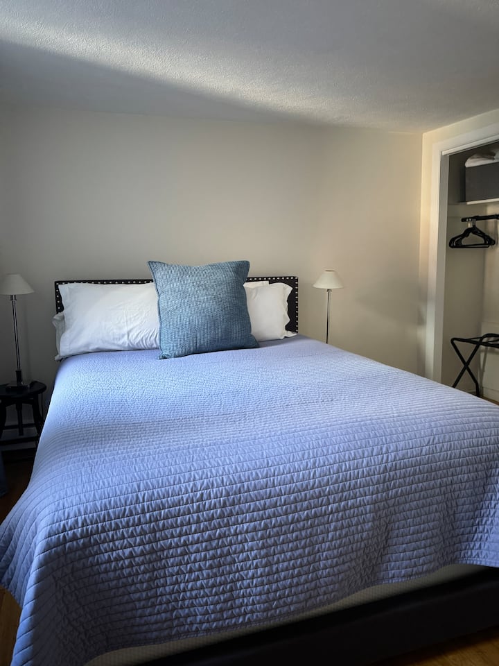 Queensize-Bett mit offenem Schrank zum Aufhängen von Kleidung oder Kommode. 