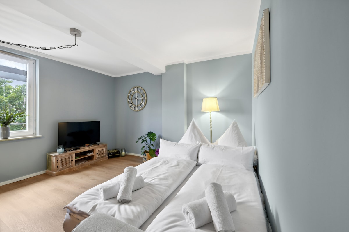 Dhomë ndenjjeje me divan dhe televizor.