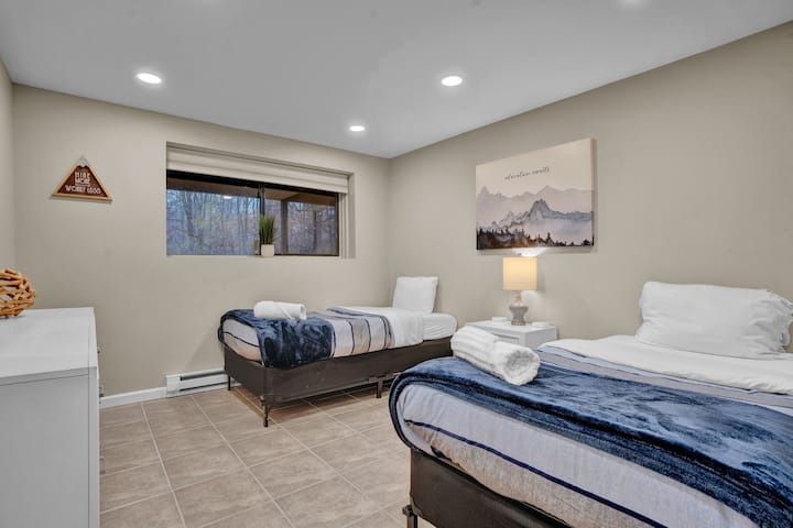 A comfortable lower-level bedroom with two single beds;  a simple, private space that’s great for friends or family.
