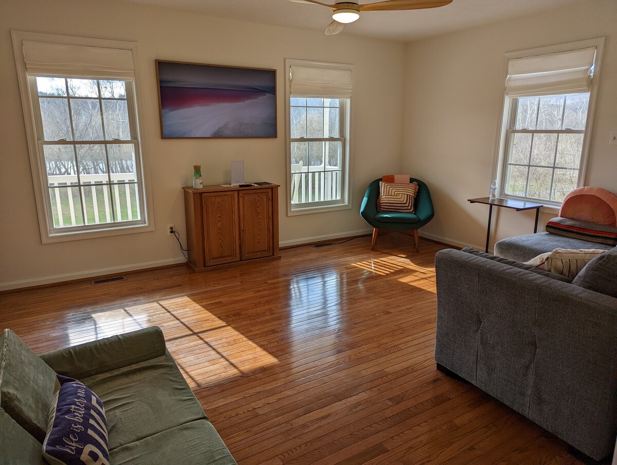 Sebule iliyo na televisheni, kochi la kuvuta na viti vya sakafuni