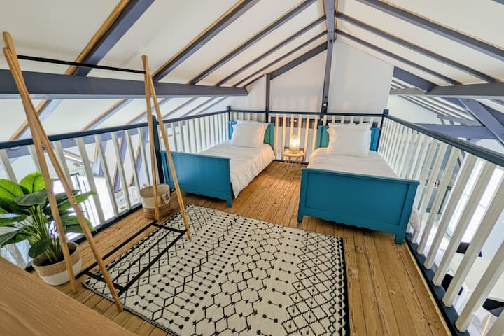 Habitación situada en la entreplanta bastante amplia con una cómoda, un cesto de ropa y un perchero