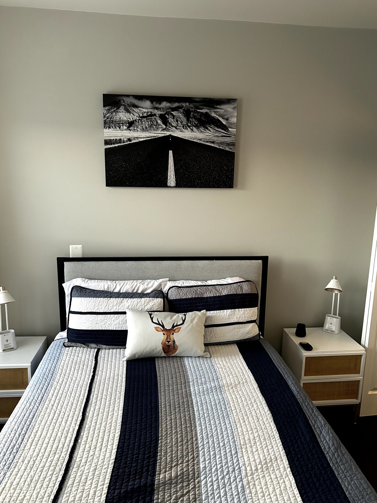 2 komodina pranë krevatit pranë abazhurëve që do të karikojnë pajisjet e tua. 