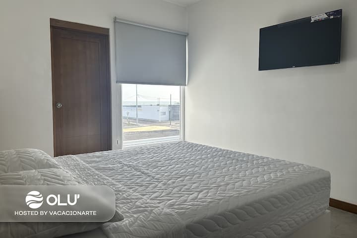 Habitación principal cuenta con televisión e una increíble vista al mar.