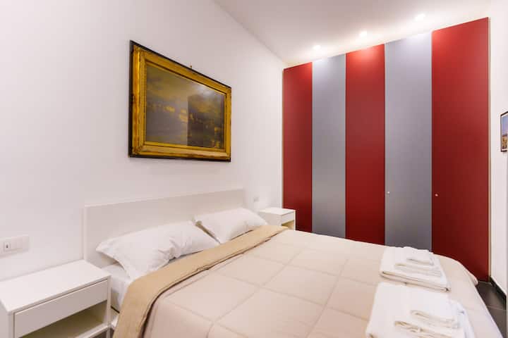 Spavaća soba s bračnim krevetom, noćnim ormarićima i posteljinom te osobnim kompletima ručnika