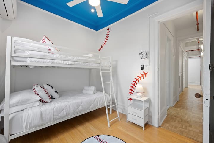 Chambre amusante et accueillante sur le thème du baseball avec un lit superposé confortable, parfaite pour les enfants ou les adultes qui cherchent à profiter d'un espace unique