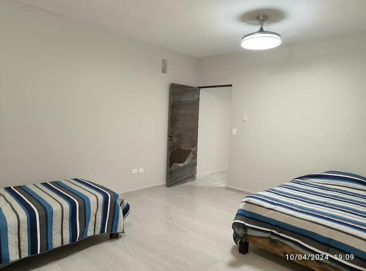Chambre très  spacieuse avec 1 lit double et un lit simple, dispose d'un bon éclairage et d'un ventilateur rétractable avec télécommande pour sélectionner différents modes d'éclairage et de ventilation. Installation de store  et accessoires en cours
