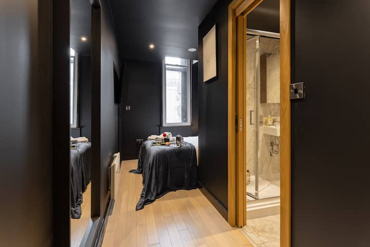 Cozy bedroom featuring a snug double bed with soft linens, and bedside lighting for thoughtful touches for a comfortable stay with a 50-inch TV ensuite with a comfortable bathroom