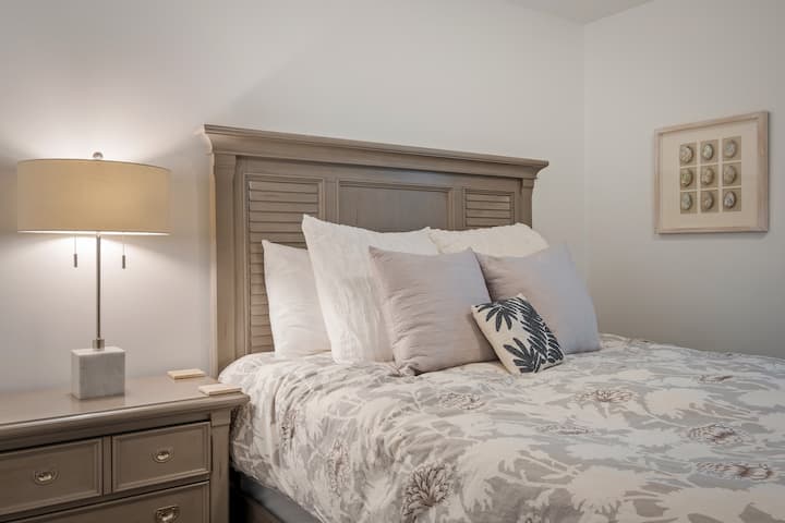 Bedroom with fluffy pillows, a stylish lamp, and all the essentials for sweet dreams.