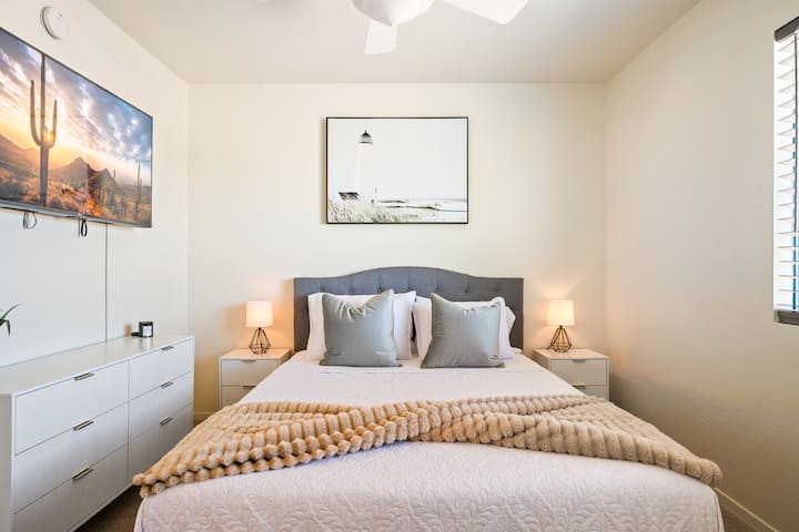 Повлечете се во оваа удобна спална соба со кадифен кревет, стилски декор и монтиран телевизор за опуштање и забава