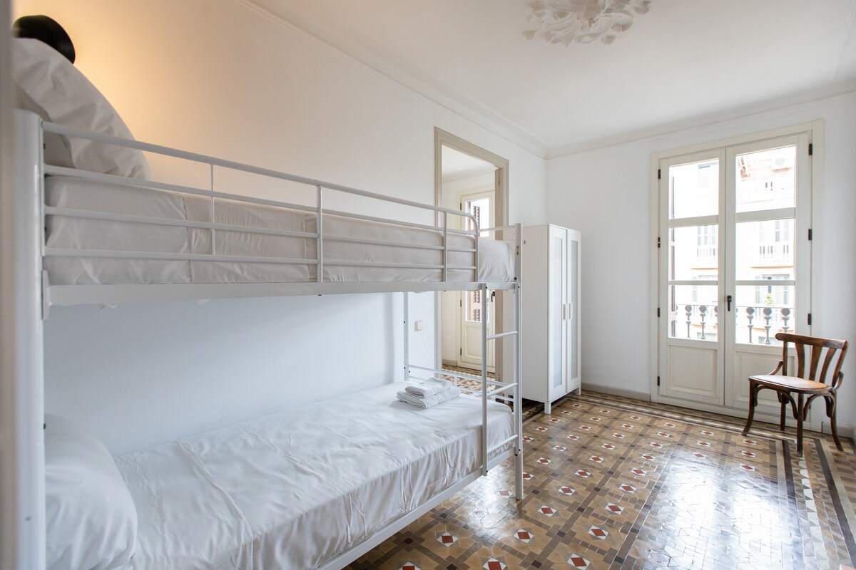 חדר שינה עם מיטת קומותיים וארון.