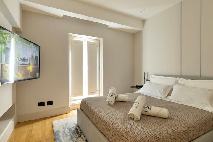 Spacious Bedroom: Relax in style with modern decor and abundant natural light! King-sized bed and flatscreen TV.