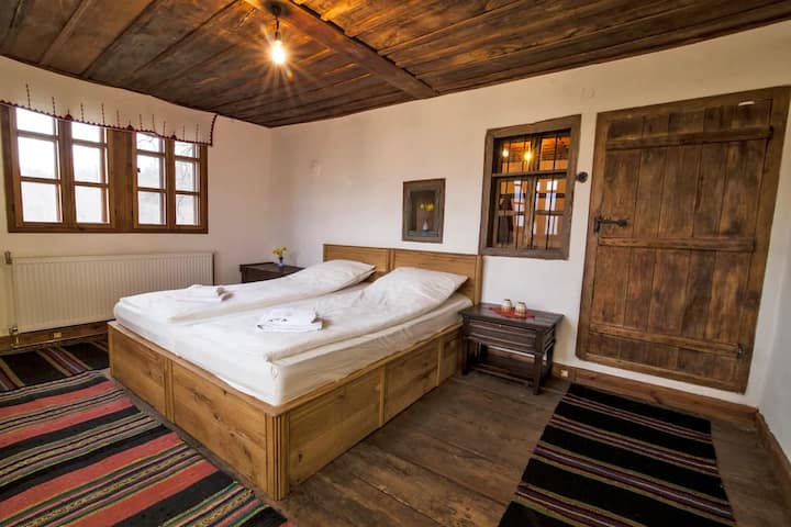 Experience the ultimate relaxation in our beautifully preserved Balkan bedroom . Featuring traditional wooden furniture, rustic design, and a warm, calming atmosphere, this space is perfect for escaping the stress of modern life.