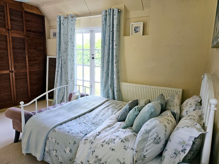 Veľká a svetlá spálňa so zabudovaným úložným priestorom a priamym prístupom do záhrady.