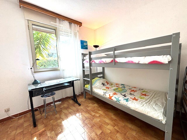 Soba s dječjim krevetima na kat i radnim stolom s pogledom na vrtnu stranu kuće