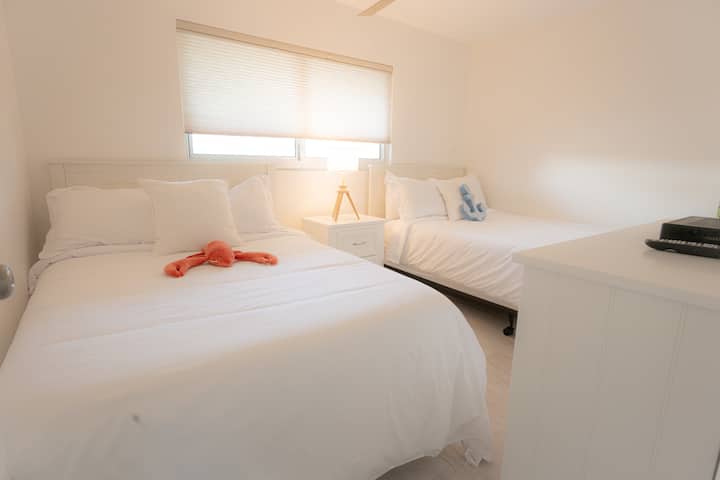 2 სრული ზომის საწოლი HD ტელევიზორითა და სააბაზანოთი პირდაპირ ოთახის მოპირდაპირე მხარეს   