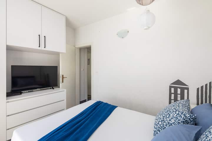 Спална соба со брачен кревет и телевизор