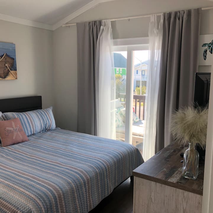 Dormitorio 1 en el piso superior con cama tamaño king y vista al mar