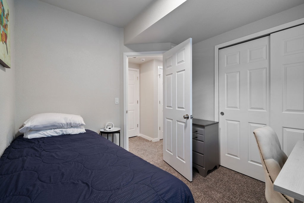 Kjo është dhoma e gjumit në katin e poshtëm. Ka një krevat të plotë, dollap, dollap të vogël, tavolinë pune me monitor dhe një makinë zëri me zhurmë të bardhë.