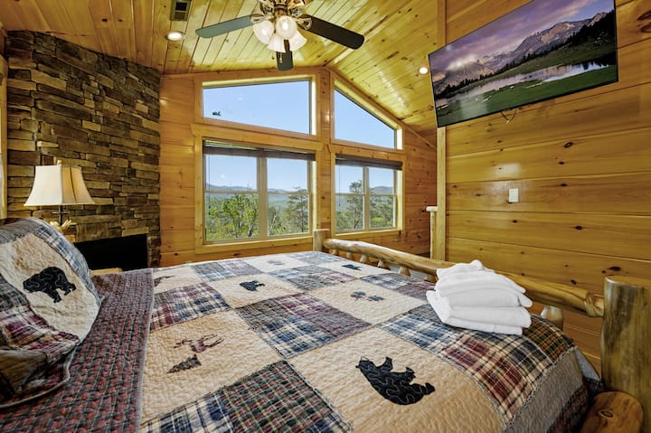 Chumba cha kulala cha msingi cha ghorofa ya juu ni sehemu ya mapumziko yenye starehe, iliyo na kitanda cha ukubwa wa kifalme, televisheni mahiri na meko yenye joto. Dari zilizopambwa na madirisha makubwa zinaonyesha mandhari ya kupendeza, na kuifanya iwe mahali pazuri pa kuamka kwa uzuri wa milima.