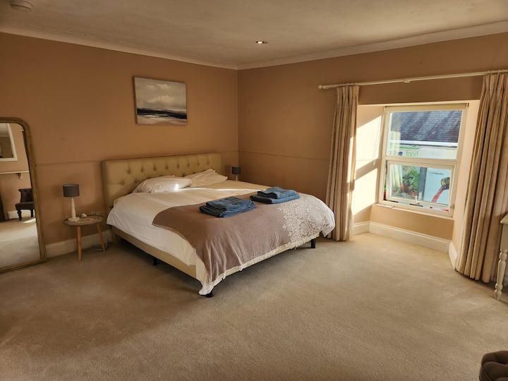 Პირველი სართულის საძინებელი სუპერთასიანი საწოლით. Ოთახში არის ტელევიზორი და სამუშაო მაგიდა.