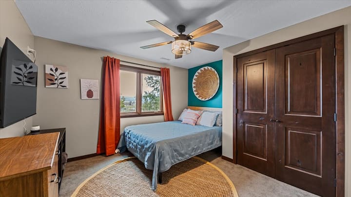 Spálňa s manželskou posteľou a televízorom na prízemí