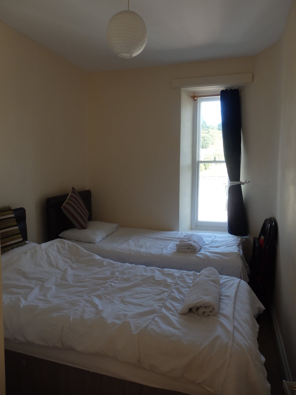 غرفة النوم الثانية - مريحة ولكن مريحة، مع سريرين مفردين. تحتوي النافذة على مزلاج أمان لمنعها من الفتح بعيدًا جدًا. 