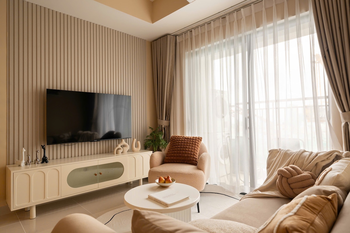 Ambient ndenjjeje i ndritshëm dhe i rehatshëm me dritë të butë natyrore, një divan prej pelushi dhe një televizor të madh inteligjent. Perdet ofrojnë privatësi të plotë kur është e nevojshme. Relaksohu me një film ose çlodhu në kolltukët e rehatshëm pas eksplorimit të qytetit. E përkryer për kafe në mëngjes ose biseda nate