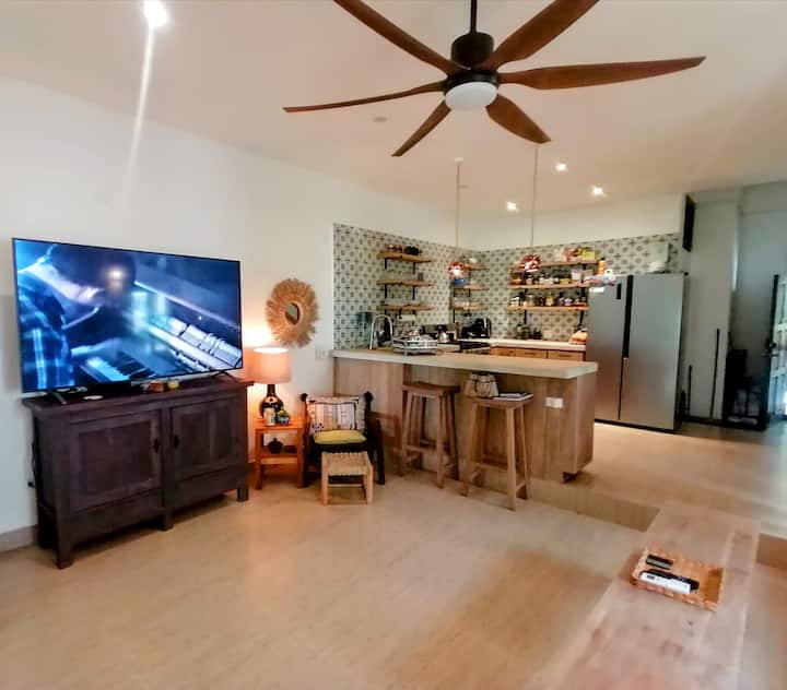 Bottom floor is open plan and includes full size kitchen, living room with 70" smart TV and dining area.