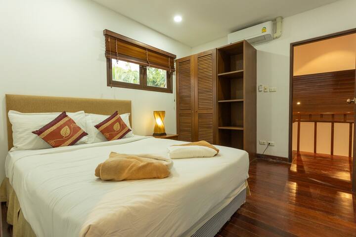 Duerme profundamente en la cama tamaño queen con sábanas suaves. Disfruta del aire acondicionado, un amplio espacio de almacenamiento de ropa y persianas que oscurecen la habitación para una noche de sueño reparador.