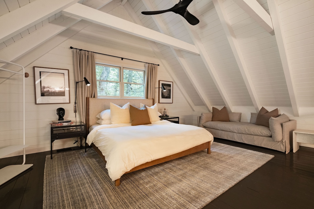 The upstairs loft overlooks the soaring ceilings and features a lounge sofa and work space for those work vacations. 