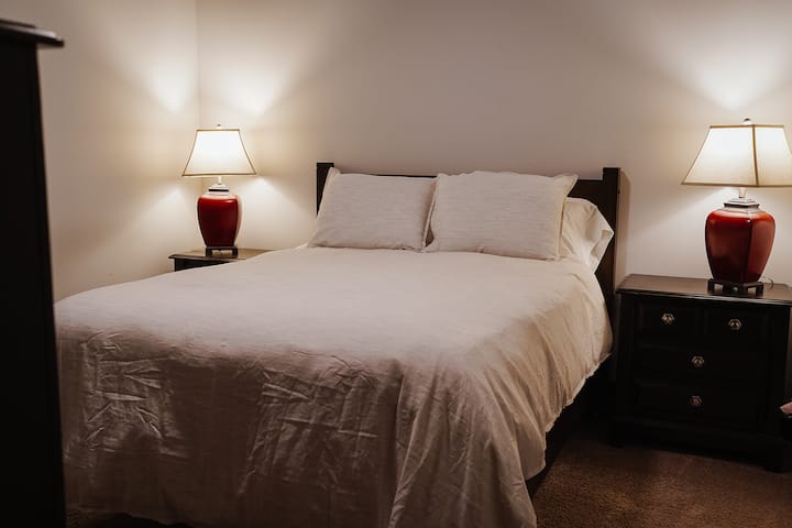 A comfy queen bed, closet, and plenty of dresser and side table doors are highlights of this quiet space.