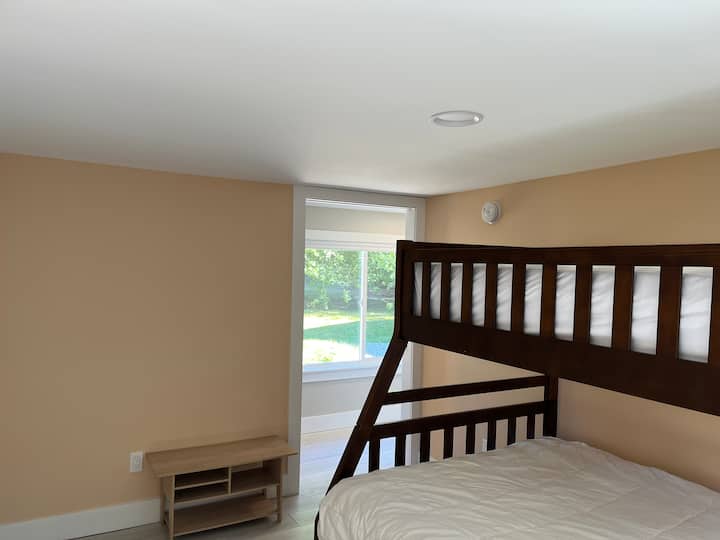 O beliche tem uma cama de solteiro em cima, uma cama completa na parte inferior, bem como uma cama de solteiro.  O corredor fica ao fundo. Este quarto fica à direita, logo após a entrada. Este quarto tem cortinas escurecidas e um ventilador de chão.