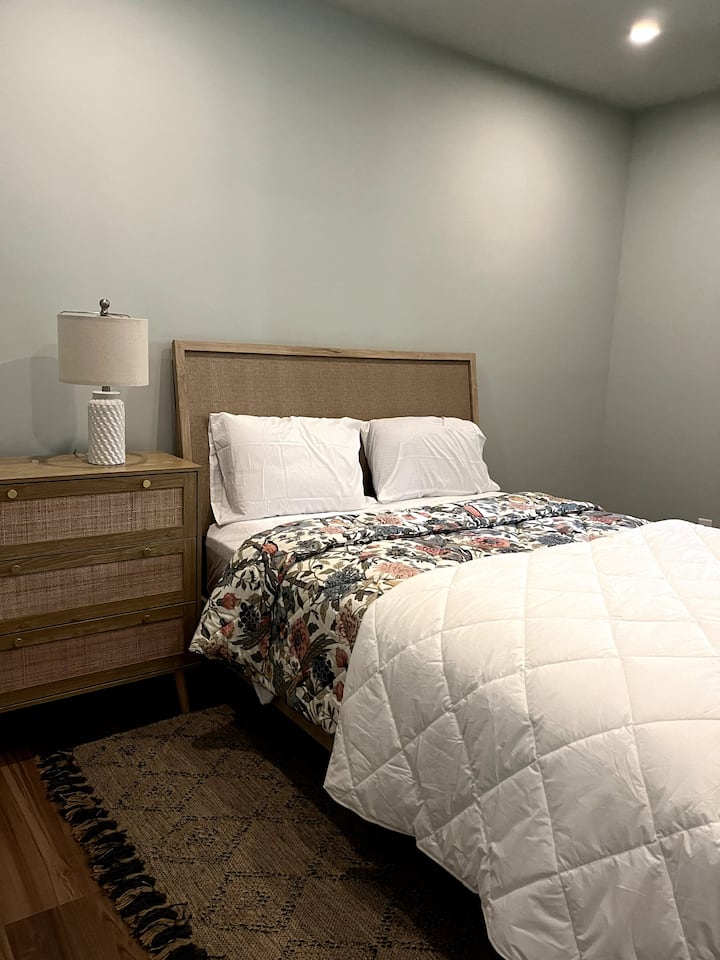 Спалня с двойно легло в мазето с голям прозорец и баня, която се ползва и от стаята с двуетажни легла.  Има и тоалетна точно пред тази спалня.