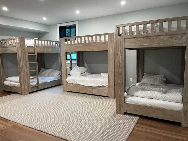 2 пълноразмерни двуетажни легла и 1 двойно двуетажно легло за спане на 9 души в тази голяма стая с двуетажни легла с прозорец и баня, която се отваря към съседна стая (споделена със съседната спалня с двойно легло).  Има и тоалетна в основната жилищна зона в мазето.