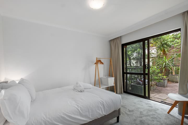 Dvojposteľ s posuvnými dverami otvárajúcimi sa do obrovského súkromného dvora s vonkajším stolom a stoličkami. Bambusový vešiak na odevy. Zablokujte závesy.