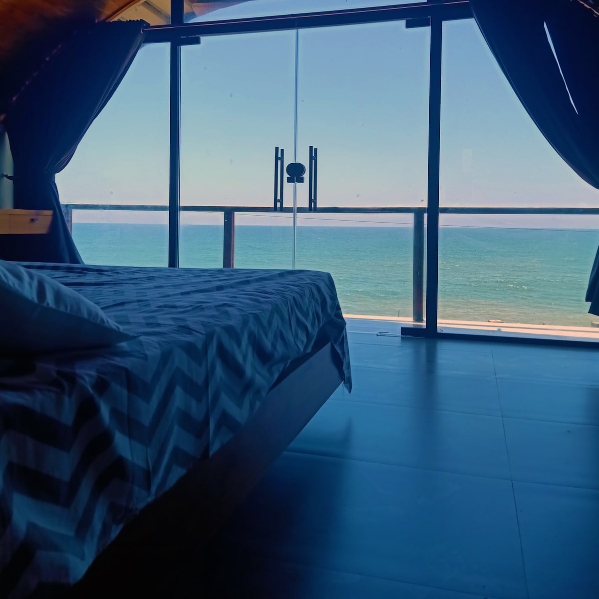 The serene and quiet atmosphere makes it an ideal space for honeymooners seeking a peaceful retreat. With its romantic and memorable setting, the bedroom creates the perfect ambiance for couples to unwind and soak in the beauty of the sea.