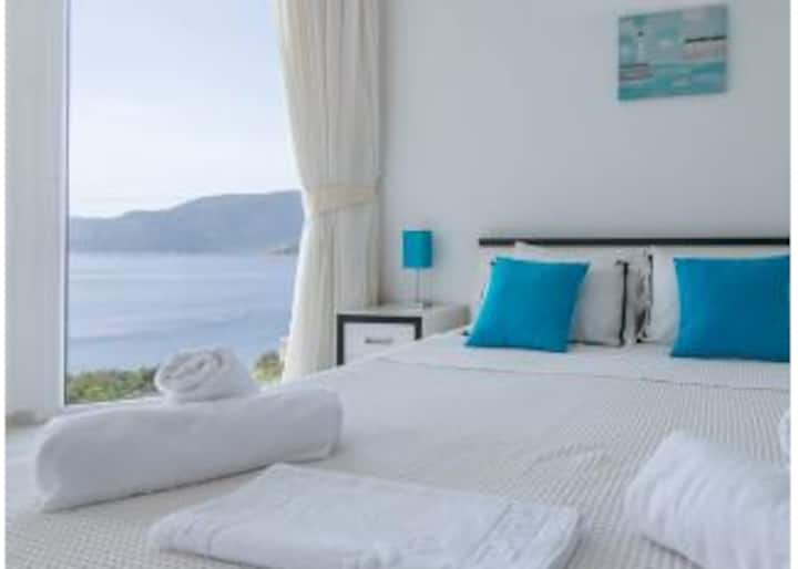 Კონდიცირებული საძინებელი აივნით, საიდანაც იშლება ხედი ზღვასა და მთებზე.