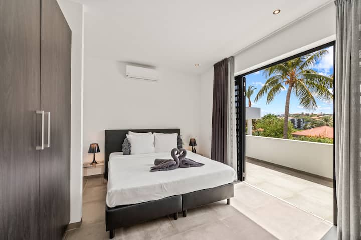 Събудете се със стил! Тази приветлива спалня съчетава комфорт с освежаваща гледка, позволявайки ви да се насладите на тропическите вибрации, когато започвате деня си. Перфектно за мързеливите сутрини!